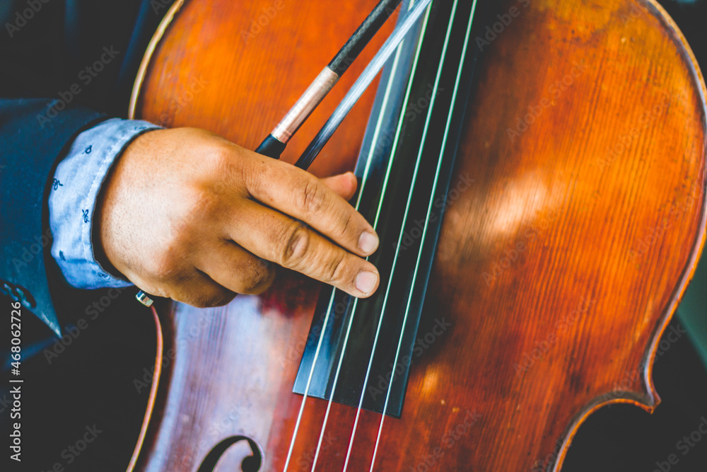Hands of a musician playing the cello with a long sleeves suit Hands of a musician playing the cello with a long sleeves suit