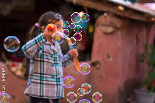 bubbles of various colors and sizes emitted by a girl in the background photo