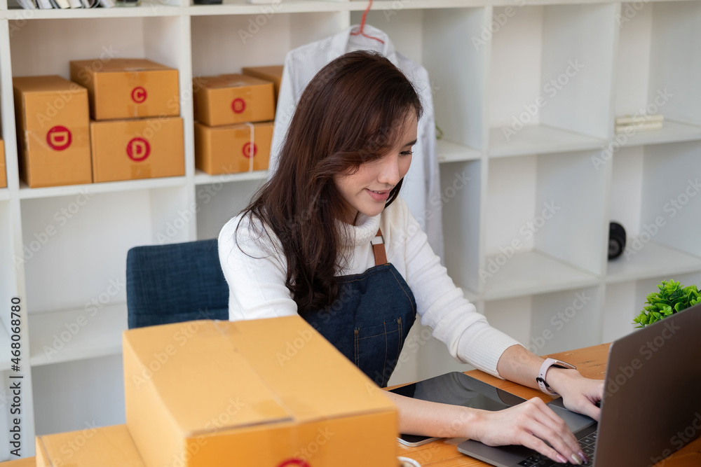 Starting Small business entrepreneur SME freelance,Portrait young woman working at home office, BOX,smartphone,laptop, online, marketing, packaging, delivery, SME, e-commerce concept. Starting Small business entrepreneur SME freelance,Portrait young woman working at home office, BOX,smartphone,laptop, online, marketing, packaging, delivery, SME, e-commerce concept.