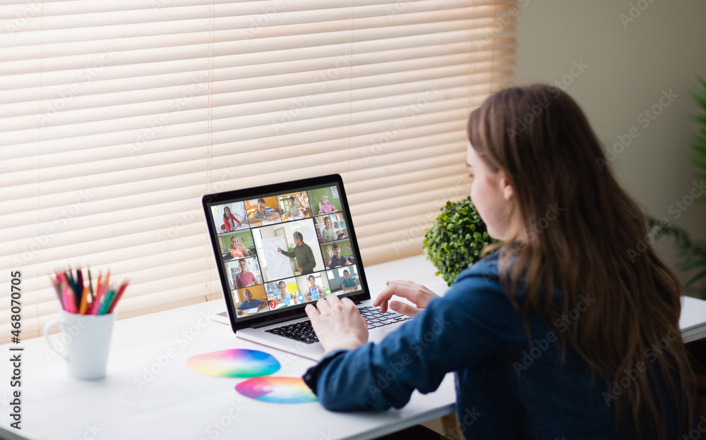 Caucasian girl using laptop for video call, with smiling diverse high school pupils on screen Caucasian girl using laptop for video call, with smiling diverse high school pupils on screen