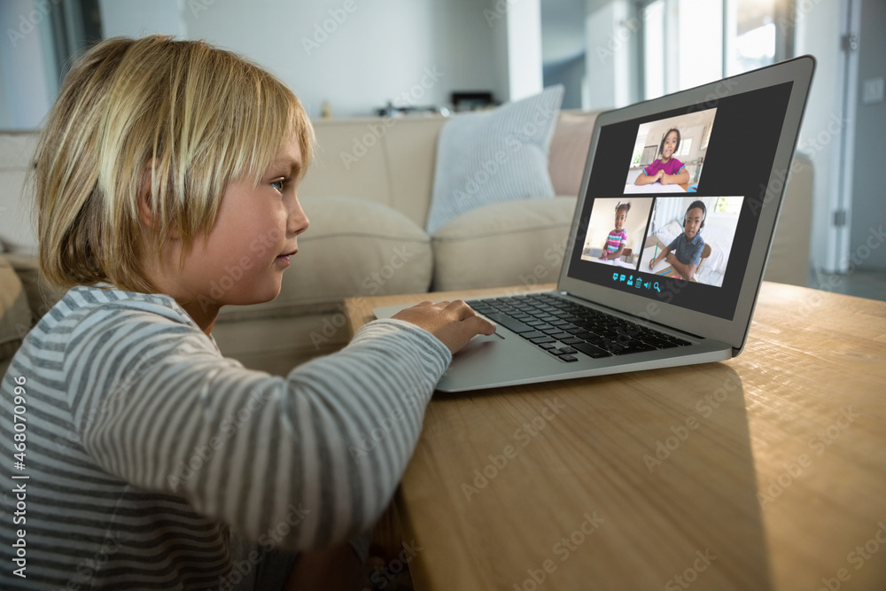 Caucasian boy using laptop for video call, with smiling diverse elementary school pupils on screen Caucasian boy using laptop for video call, with smiling diverse elementary school pupils on screen