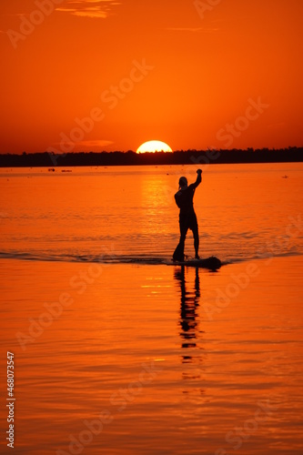 persona practicando paddle surf al atardecer © NachoDavvidPH