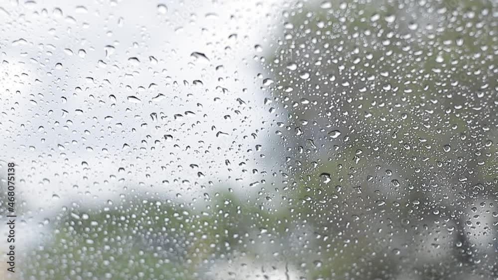 Water droplets falling on a car glass. rain falling on the window. Water falls on rainy days. Water droplets falling on a car glass. rain falling on the window. Water falls on rainy days.