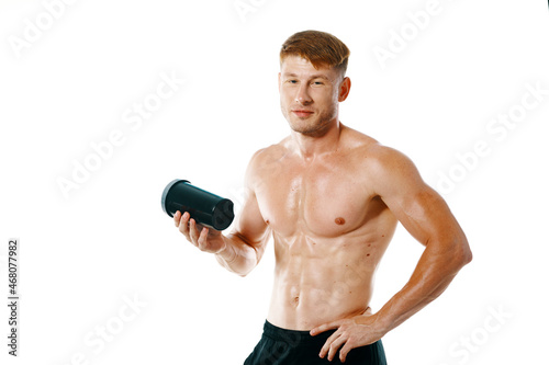 a man an athlete with a pumped-up body drinks from a bottle