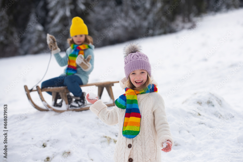Child girl enjoying snow ball play outdoors. Kids sled in the Alps mountains in winter. Outdoor fun for family christmas vacation.