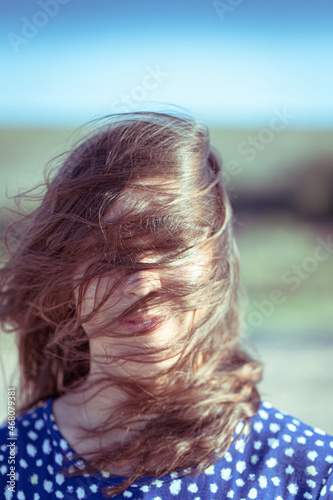 Portrait of a woman with fluttering hair in the wind. The concept of pleasure and enjoyment.