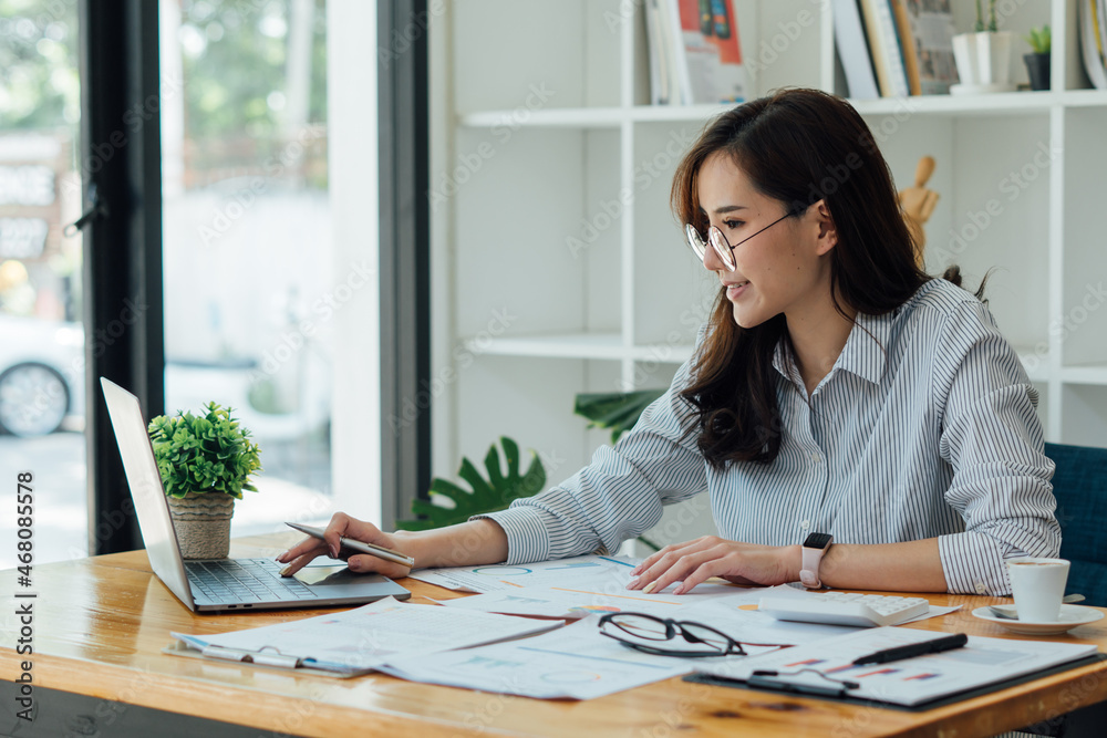 Asian female accountant or banker making calculations. Savings, finances and economy concept. Asian female accountant or banker making calculations. Savings, finances and economy concept.
