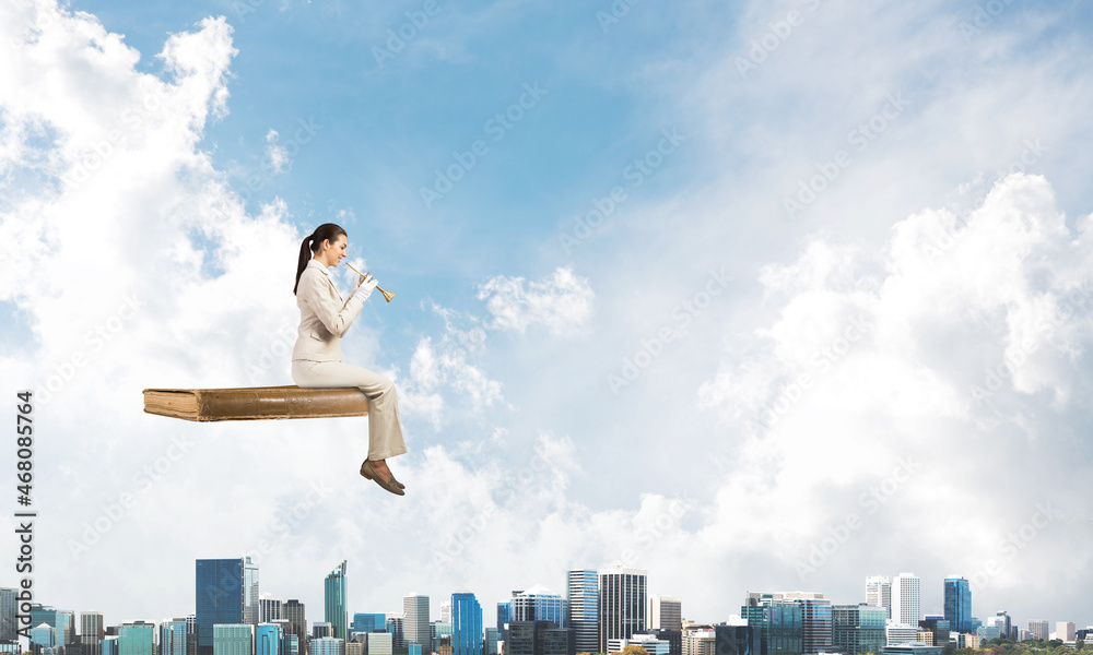 Elegant woman in business suit sitting on book Elegant woman in business suit sitting on book