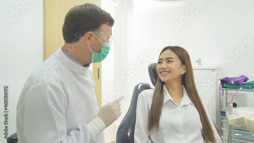 A portrait of a dentist and Asian patient talking  smiling at hospital clinic. Teeth check up with dental tools. Doctor. Dentistry  medical and health. People.