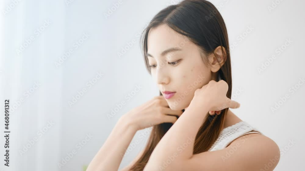 ヘアケアをする若い女性 ヘアケアをする若い女性