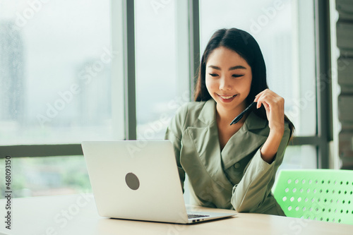 Businesswoman are smile and using computer at window office Trade stock market