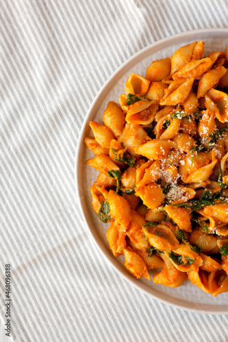 Homemade Pumpkin Pasta with Walnuts and Spinach, top view. Flat lay, overhead, from above. Space for text.