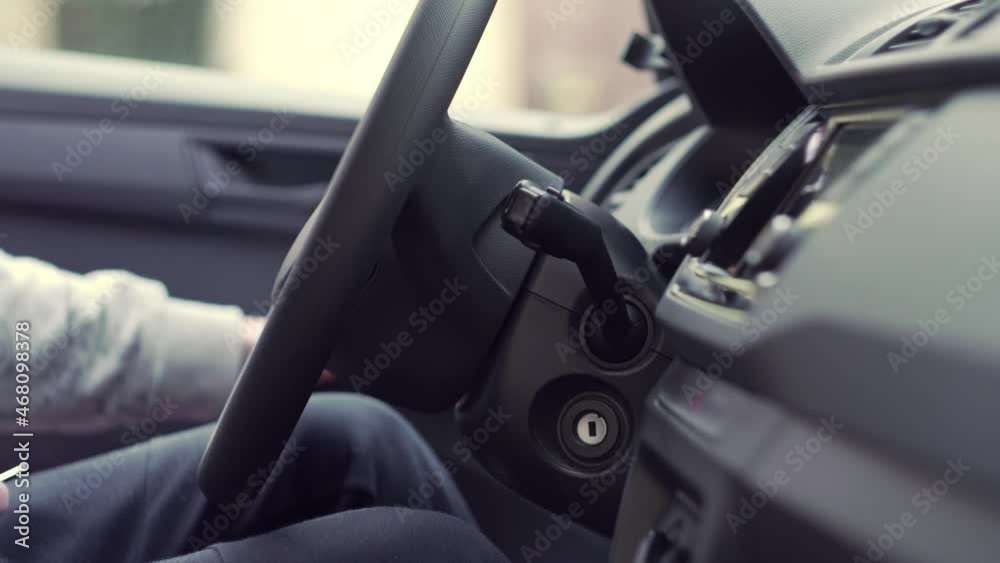 Getting in car, closing door and starting with keys in hand, closeup interior view