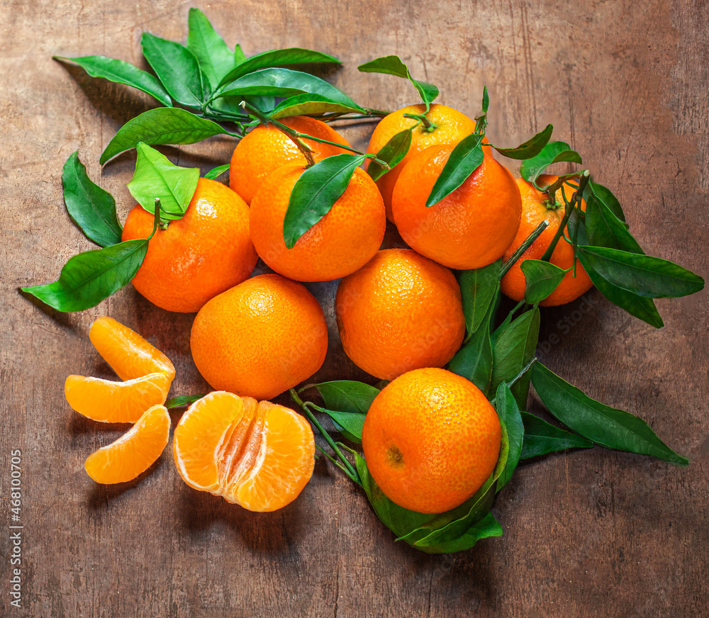 Mandarin oranges fruits or tangerines with leaves on a wooden table. Copyspace. Fresh picked mandarins Top view. Flat lay.
