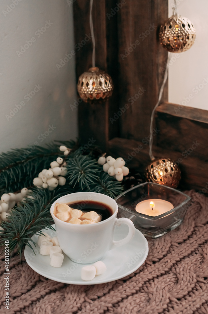 Fototapeta premium a cup of coffee with white berries, spruce branches, a garland and marshmallows