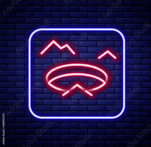 Glowing neon line Winter fishing icon isolated on brick wall background. Round ice frame. Hole in ice. Colorful outline concept. Vector