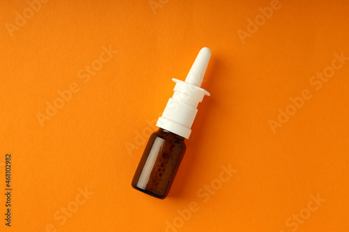 Blank bottle of nasal spray on orange background