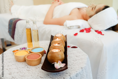 spa composition set and young woman lying in bed and relaxing in massage room