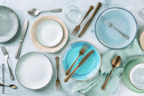Modern tableware set with cutlery and a vibrant blue plate, overhead flat lay shot photo