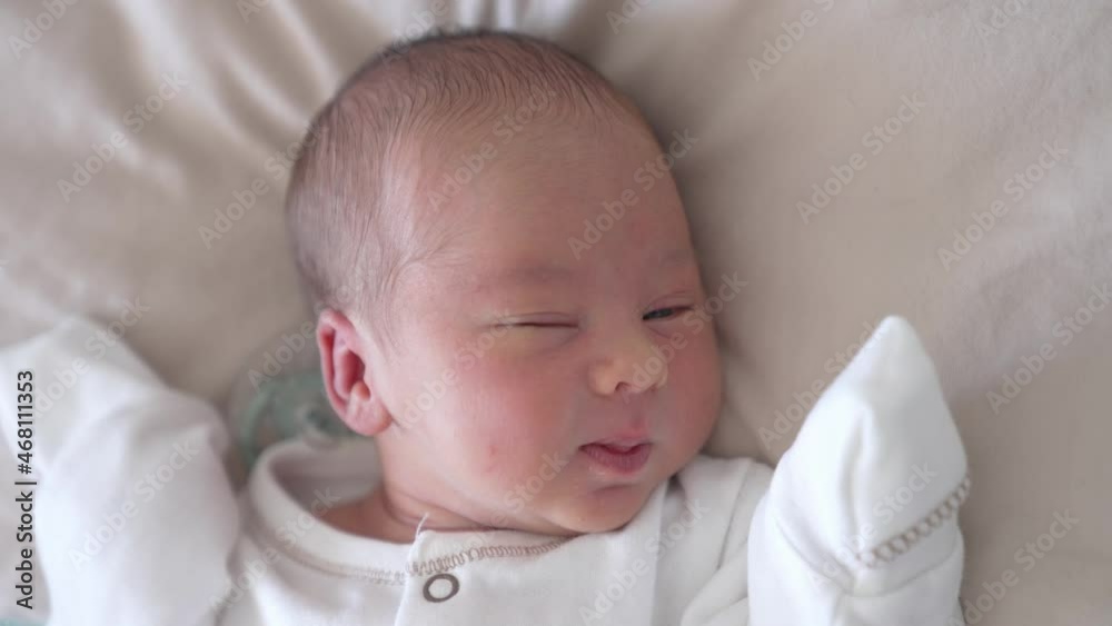 Close up view of small cute baby in light cloth. Beautiful little newborn laying on white blanket. Close up view of small cute baby in light cloth. Beautiful little newborn laying on white blanket.