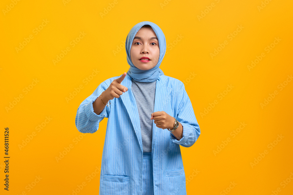 Angry young Asian woman doing warning sign isolated over yellow background Angry young Asian woman doing warning sign isolated over yellow background