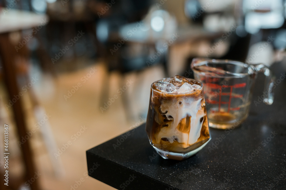 iced coffee with milk  served on the black table at a cafe​
