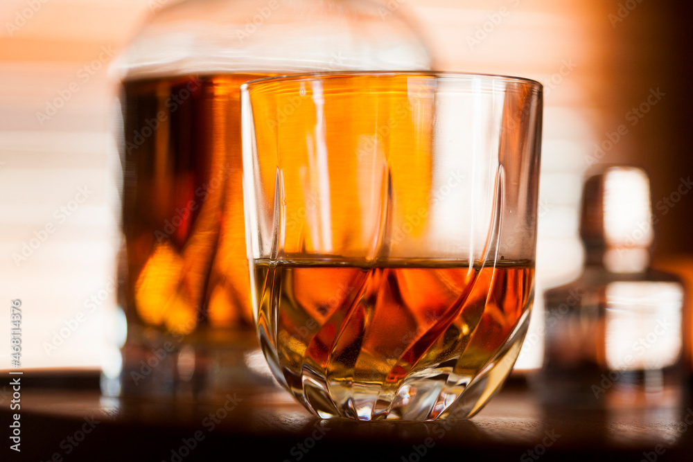 Whiskey glass close up in a dark bar setting. Selective focus on the glass. Copy space.High quality photo Whiskey glass close up in a dark bar setting. Selective focus on the glass. Copy space.High quality photo