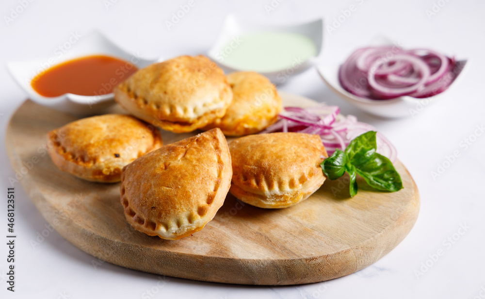 Homemade empanadas with sauces. South American street food. These delicious beef empanadas are mandatory to eat, they have a crunchy dough and an exquisite ground beef filling.