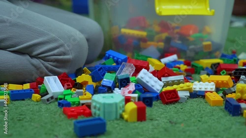 Little child playing and tidy up a  lots of colorful plastic building blocks. photo