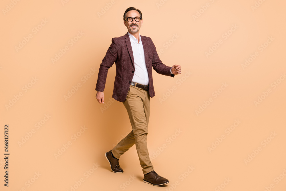 Full length body size view of attractive cheery successful man top director strolling isolated over beige color background Full length body size view of attractive cheery successful man top director strolling isolated over beige color background