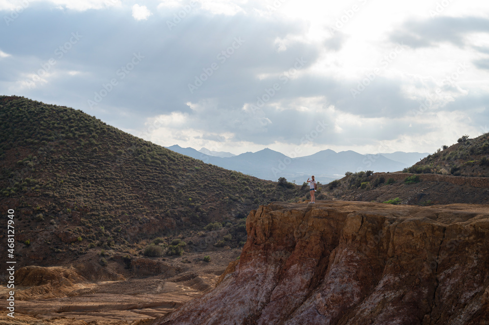 Obraz premium Adventurous young girl taking pictures in the mountains of the Mazarron desert