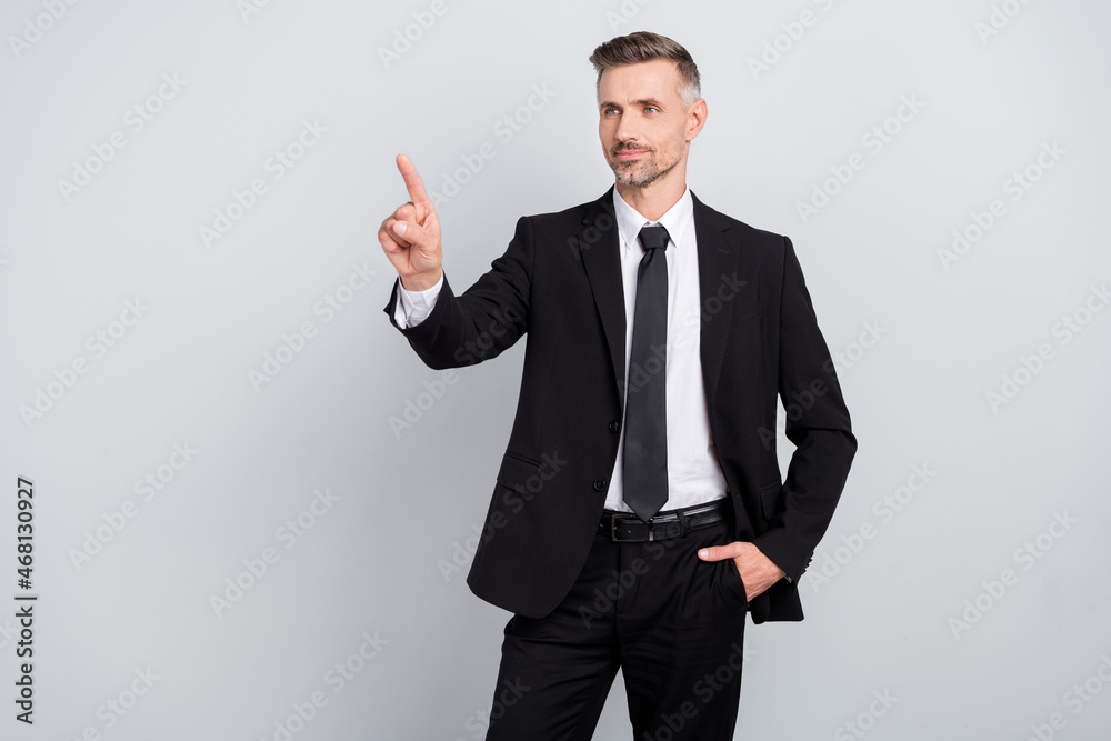 Photo of smiling positive young advisor wear black jacket touch empty space isolated grey color background Photo of smiling positive young advisor wear black jacket touch empty space isolated grey color background