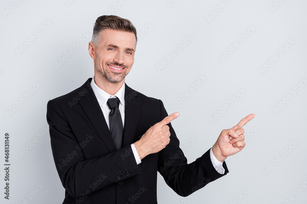 Photo of confident cheerful mature lawyer dressed black suit pointing two fingers empty space isolated grey color background Photo of confident cheerful mature lawyer dressed black suit pointing two fingers empty space isolated grey color background