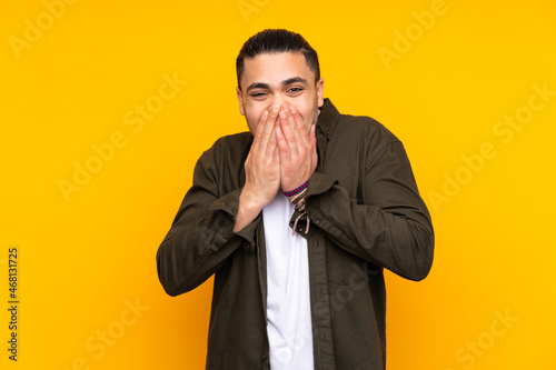 Asian handsome man isolated on yellow background showing ok sign with fingers