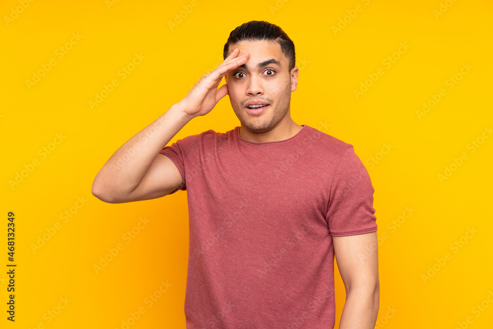 Asian handsome man isolated on yellow background holding copyspace imaginary on the palm to insert an ad and with thumbs up Asian handsome man isolated on yellow background holding copyspace imaginary on the palm to insert an ad and with thumbs up