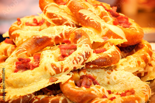 Hot delisious pretzels with ham and cheese for sale at Christmas market in Paris, France. Traditional comfort food background. photo