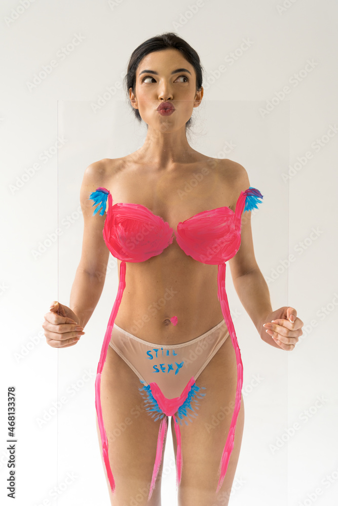 Naklejka premium Woman showing funny face while holding glass with drawing hairy unshaven female armpits