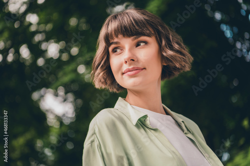 Portrait of attractive carefree brown-haired girl enjoying spending time in forest wood garden outdoors