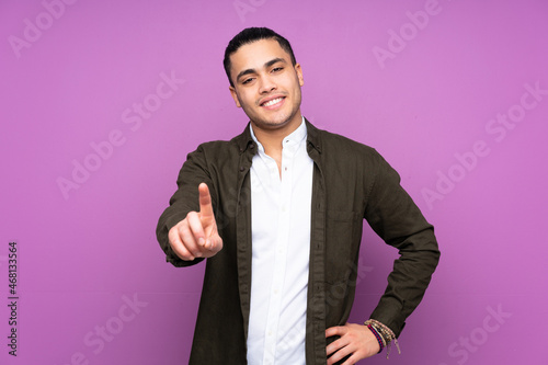 Asian handsome man isolated on blue background showing and lifting a finger