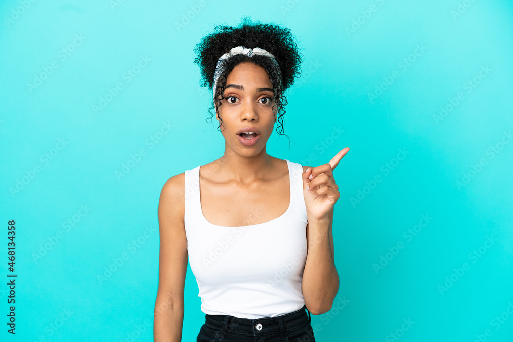 Young latin woman isolated on blue background intending to realizes the solution while lifting a finger up Young latin woman isolated on blue background intending to realizes the solution while lifting a finger up
