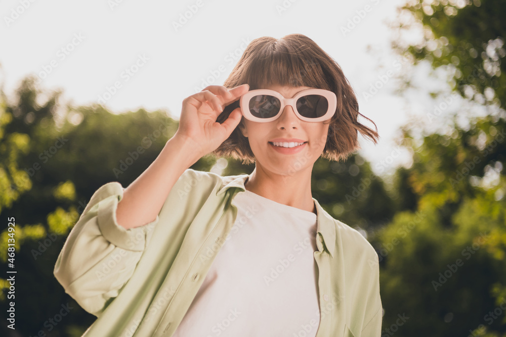 Portrait of attractive cheerful carefree girl wearing touching specs accessory pastime vacation good mood on fresh air outdoors Portrait of attractive cheerful carefree girl wearing touching specs accessory pastime vacation good mood on fresh air outdoors