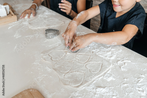 Children making cookies in the kitchen at home.