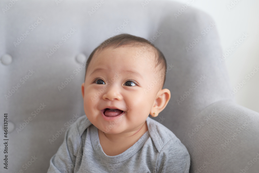 pretty baby sitting and smiling on the sofa pretty baby sitting and smiling on the sofa