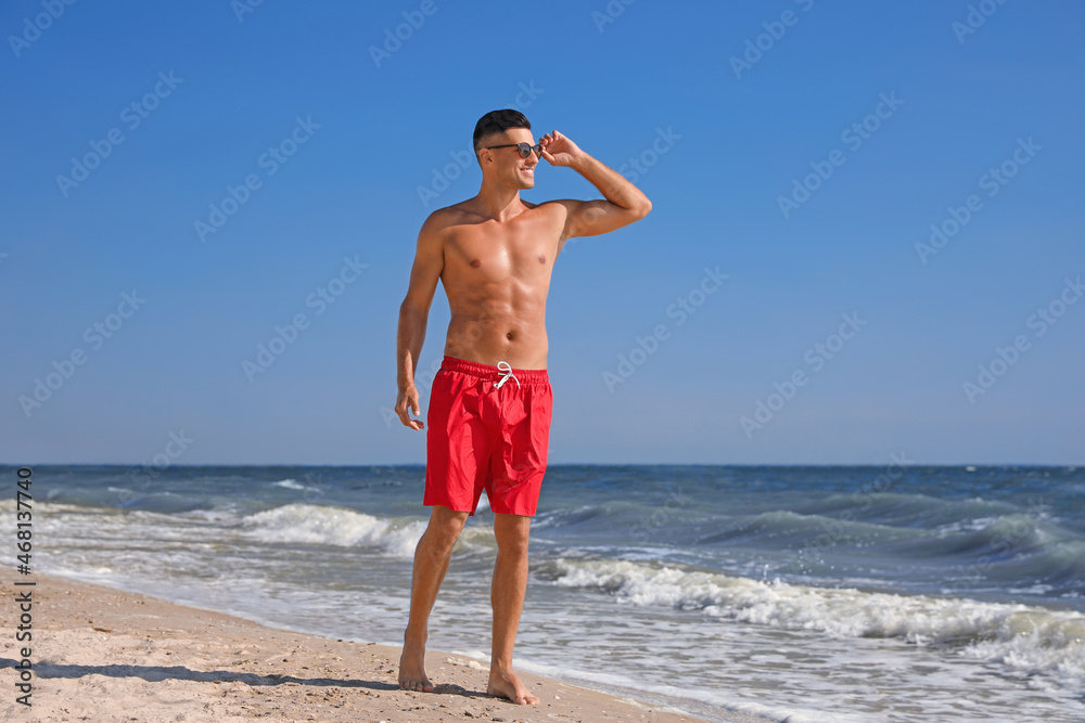 Handsome man with attractive body on beach