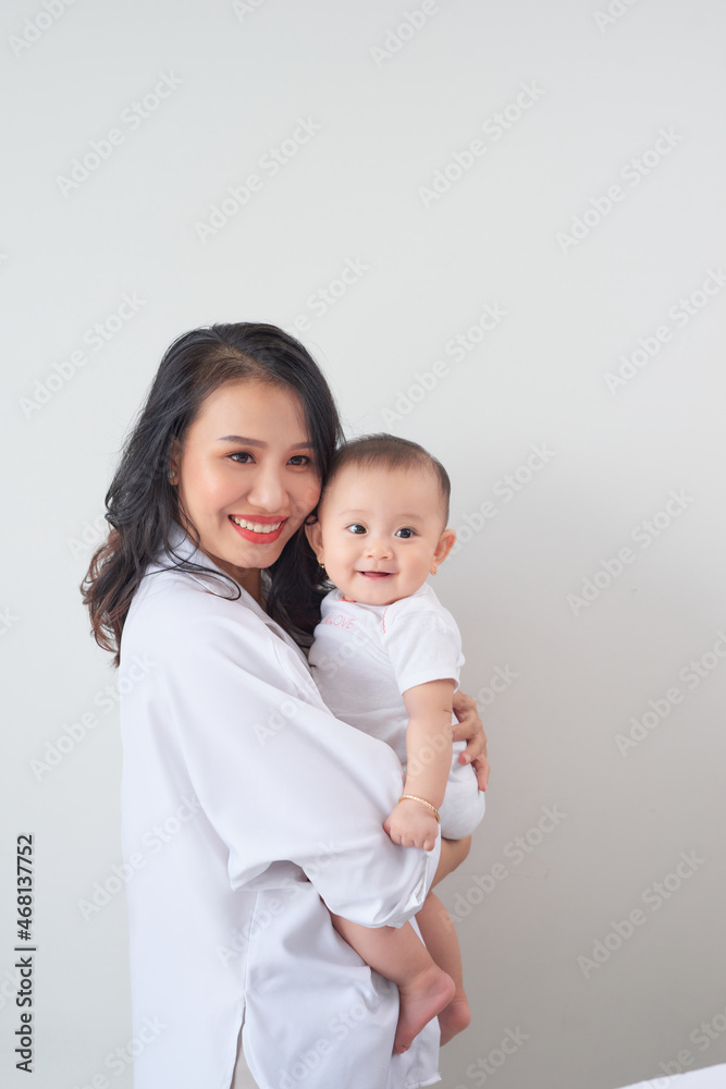 Portrait of a beautiful mother smiling with her baby in bedroom Portrait of a beautiful mother smiling with her baby in bedroom