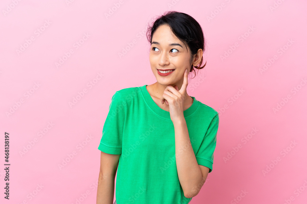 Young Vietnamese woman isolated on pink background thinking an idea while looking up Young Vietnamese woman isolated on pink background thinking an idea while looking up