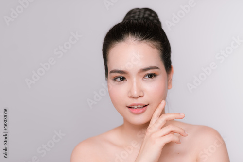 Happy young woman face with clear skin on gray background, closeup portrait
