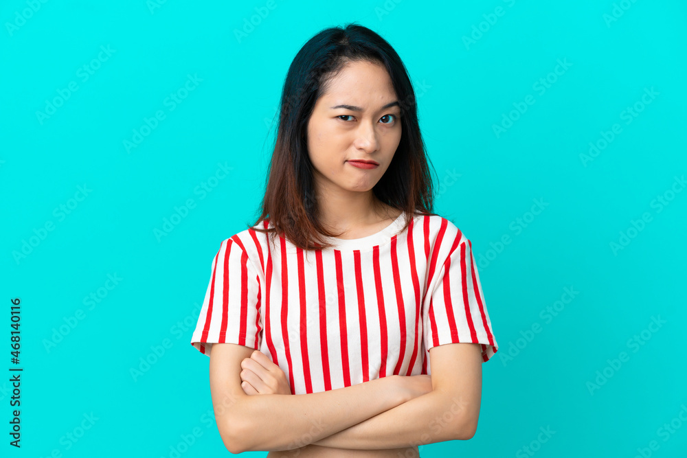 Young Vietnamese woman isolated on blue background with unhappy expression Young Vietnamese woman isolated on blue background with unhappy expression