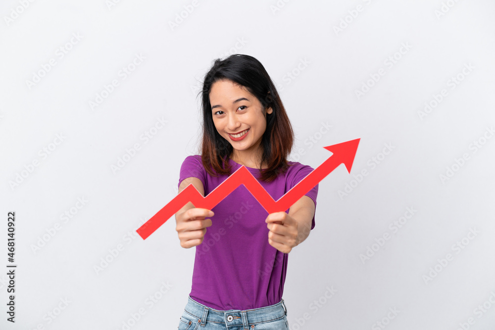 Young Vietnamese woman isolated on white background holding a catching a rising arrow with happy expression Young Vietnamese woman isolated on white background holding a catching a rising arrow with happy expression
