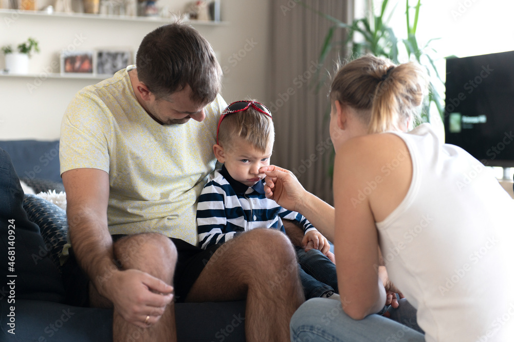 dad and mom comfort an crying baby, mother wip his tears dad and mom comfort an crying baby, mother wip his tears